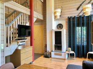 a living room with a tv and a fireplace at Petäjähovi in Kuusamo