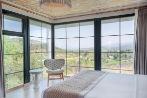 a bedroom with a bed and a chair and windows at Baska Urla Otel in Denizli +67 photos