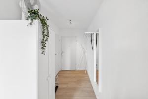 un pasillo con paredes blancas y una planta en la pared en Go2Cozy - Study & Work Apartments - WIFI - Kitchen, en Kaiserslautern 17 fotos más