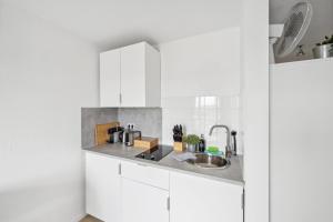 Una cocina con gabinetes blancos y un fregadero. en Go2Cozy - Study & Work Apartments - WIFI - Kitchen, en Kaiserslautern