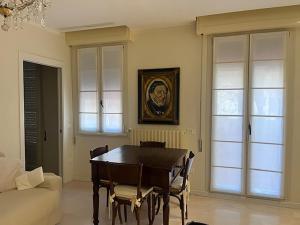 a dining room with a table and chairs and a couch at Casa del Teatro appartamento con splendida terrazza di fronte al Teatro Rossini in Pesaro