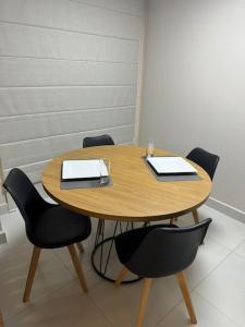 a wooden table with chairs and papers on it at Apartamento 121 - Home in Ribeirão Preto +2 photos