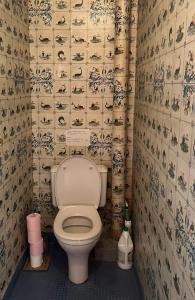 - une salle de bains avec toilettes dans une chambre avec papier peint dans l'établissement Appartement vintage Bastia - MAGNIFIQUE VUE !, à Bastia