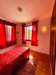 a bedroom with a red bed and red curtains at Seaside Beach Bungalow in Dar es Salaam