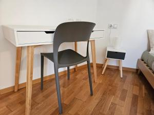 a desk with a chair next to a bed at mama's room in Egna