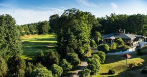 eine Luftaufnahme eines Golfplatzes mit einem Haus und Bäumen in der Unterkunft Precise Resort Scharmützelsee - Golf & SPA in Bad Saarow