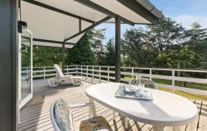 ein weißer Tisch und Stühle auf einer Holzterrasse in der Unterkunft Holiday Home Malurtvej Aakirkeby Iv in Vester Sømarken