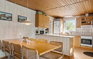 eine große Küche mit Holztisch und Stühlen in der Unterkunft Holiday Home Malurtvej Aakirkeby Iv in Vester Sømarken