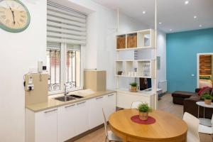 a kitchen and living room with a table and a clock at Modern and spacious-2Bedrooms 1Bathroom-Malasaña in Madrid +9 photos