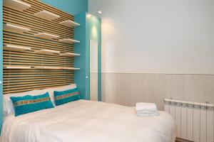 a bedroom with a large white bed with blue walls at Modern and spacious-2Bedrooms 1Bathroom-Malasaña in Madrid