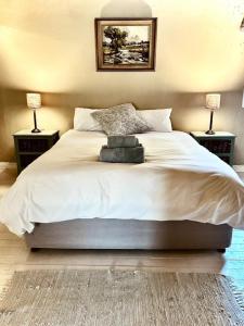 a bedroom with a large bed with two lamps at Simunye Cottage in Simondium +5 photos