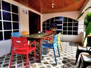 a dining room with a table and colorful chairs at 3 Bed House - Sleeps 20 - Pets - Pool - Garden in Caba
