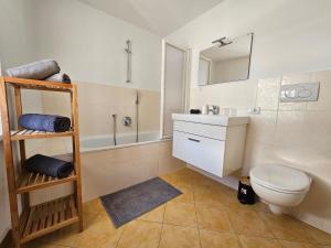 a bathroom with a toilet and a sink and a tub at mama's room in Egna