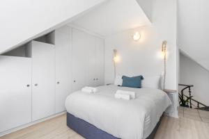 1 dormitorio blanco con 1 cama grande con armarios blancos en Summerville Beach Loft by Host Agents, en Ciudad del Cabo