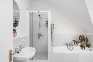 Un baño blanco con lavabo y ducha. en Summerville Beach Loft by Host Agents, en Ciudad del Cabo 24 fotos más