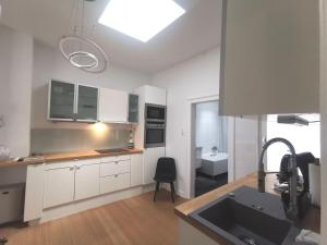 une cuisine avec des armoires blanches et un évier dans l'établissement Stadtappartement Miltenberg Perle am Main, à Miltenberg 9 autres photos