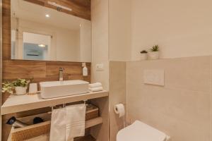 un bagno con lavandino, WC e specchio di Rio Verde - Milano 3 a Basiglio Altre 38 foto