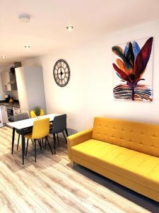 a living room with a yellow couch and a table at Belfast View Apartment in Belfast