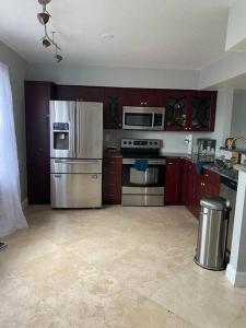 an empty kitchen with stainless steel appliances and cabinets at Hollywood Townhouse steps to beach and famous Broadwalk in Hollywood Beach