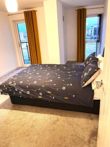 a bedroom with a bed with a black comforter at Belfast View Apartment in Belfast