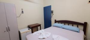 a bedroom with a bed with blue pillows on it at HOTEL TROPICAL in Cuiabá