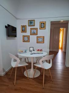 a white dining room with a white table and chairs at Antica Sicilia Luxury in Regalbuto