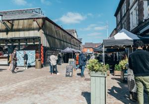 a group of people walking around an outdoor market at The Railway Pass The Keys Modern 2-Bed Apartment in Central Altrincham in Altrincham