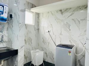 a bathroom with a white marble wall at Evara Green Luxurious 3BHK Apartment in Lingampalli +27 photos