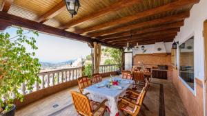 a dining room with a table and chairs on a balcony at Castillo de la Hazalara Cómpeta by Ruralidays in Cómpeta