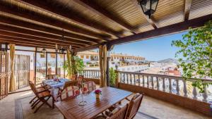 a patio with a table and chairs on a balcony at Castillo de la Hazalara Cómpeta by Ruralidays in Cómpeta