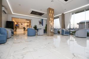 a lobby with blue and white furniture and windows at شقق إطلالة الواحة للشقق المخدومة - إقتصادي in Al Majma'ah