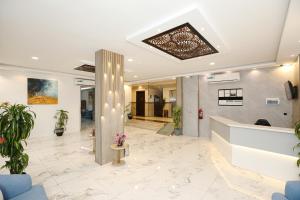 an office lobby with a reception desk and potted plants at شقق إطلالة الواحة للشقق المخدومة - إقتصادي in Al Majma'ah