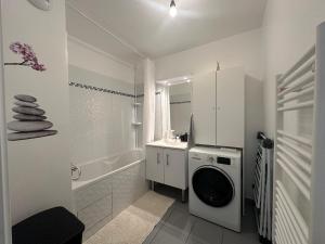 a white bathroom with a washing machine in it at Aéroport CDG, Paris Disneyland, Eiffel Tower, JO 2024 in Montévrain