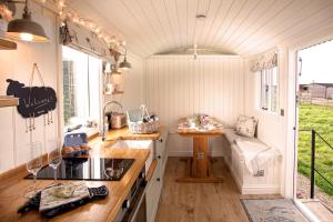 a kitchen in a tiny house with a bench in it at Starlight Shepherd Hut in Littleworth