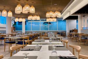 a dining room with tables and chairs and chandeliers at Hotel Don Juan Tossa in Tossa de Mar