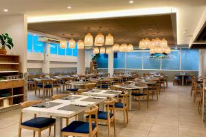 a dining room with tables and chairs and chandeliers at Hotel Don Juan Tossa in Tossa de Mar
