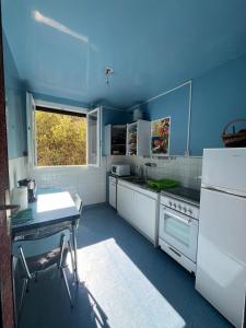 - une cuisine avec des murs bleus et des appareils blancs dans l'établissement Appartement vintage Bastia - MAGNIFIQUE VUE !, à Bastia 19 autres photos