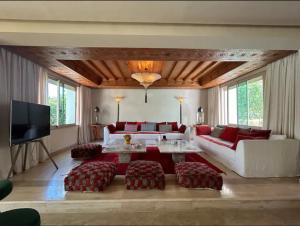 - un salon avec un canapé blanc et des meubles rouges dans l'établissement Villa golf amelkis Marrakech, à Sfiani