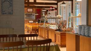 a restaurant with a counter with chairs and tables at Hotel Pousada Ald' Mama in Gramado