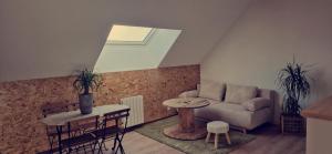a living room with a couch and a table at appartement dans une écurie in Amillis