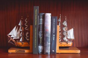a group of books on a shelf with a model ship at Hotel Skala in Biała Podlaska