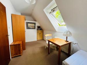 Cette chambre mansardée comprend une table et une fenêtre. dans l'établissement Süden, à Fehmarn