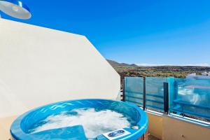 una bañera azul llena de agua en el balcón en La Mar Loft Apartment with Hot Tub, en Puertito de Güímar