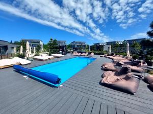 a large swimming pool with pillows on a wooden deck at Apartamentai in Palanga