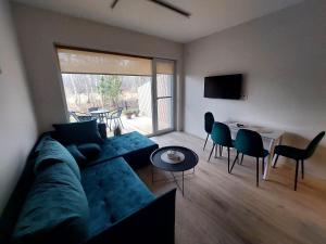 a living room with a couch and a table and chairs at Apartamentai in Palanga