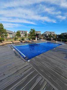 a swimming pool on top of a wooden deck at Apartamentai in Palanga