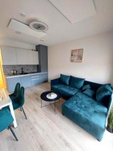 a living room with a green couch and a table at Apartamentai in Palanga