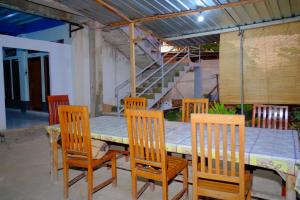 ラブハン・バジョにあるGalung Homestay Labuan Bajoのダイニングルームのテーブル、椅子、テーブル、階段
