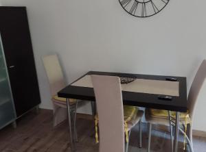 a black table with chairs and a clock on the wall at Holiday Home Vrata Bedemgrada in Našice