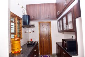 蒂鲁帕蒂SHALOM RESIDENCE - 2BHK-AC Service Apartments, Premium amenities, Kitchen with Stovetop, WiFi的厨房设有木制橱柜和木门。 更多2张照片